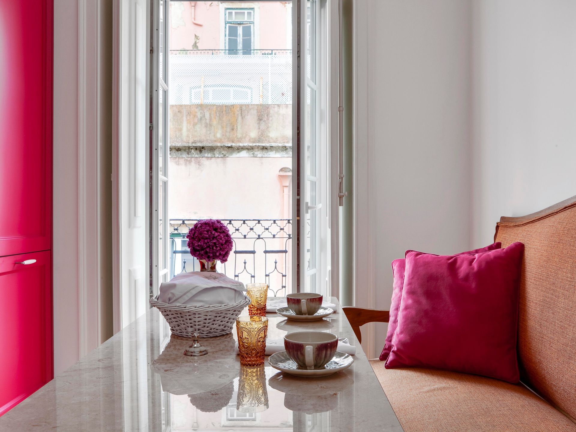 View from a window in a duplex one-bedroom apartment with pink decor and a decorative vase.