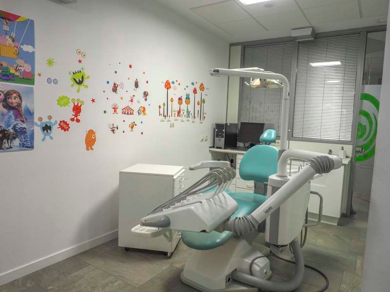 Un consultorio dental con un sillón dental y una computadora.