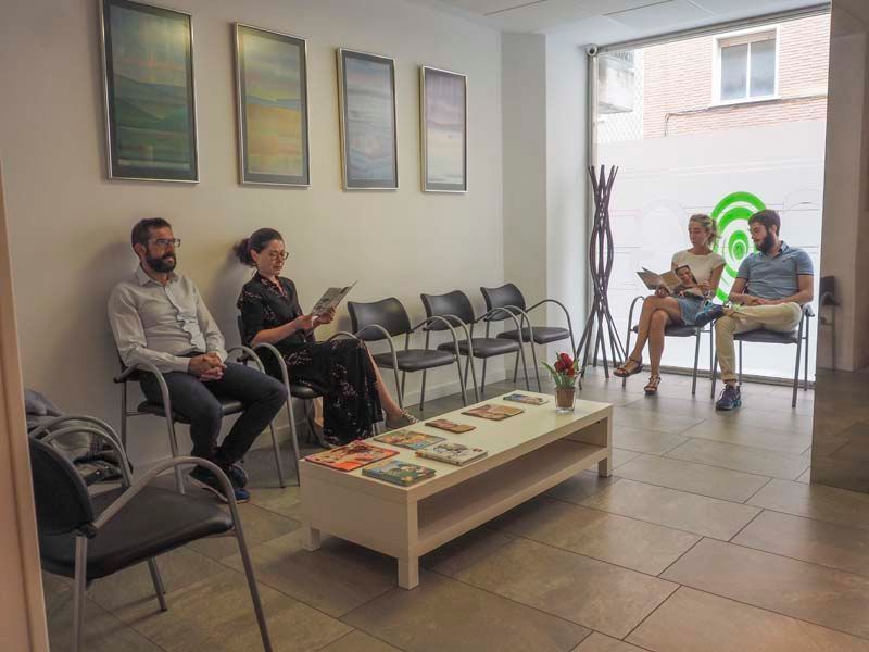 Un grupo de personas está sentada en una sala de espera.