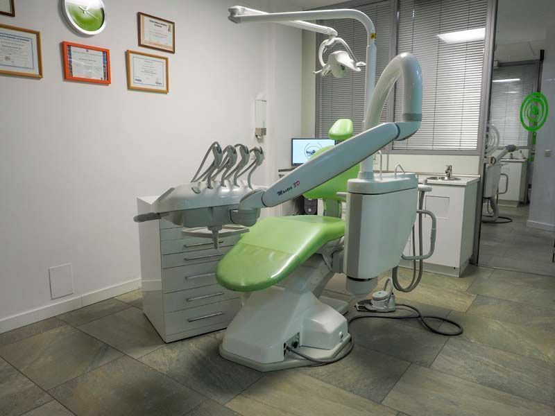 En un consultorio dental hay una silla dental verde.