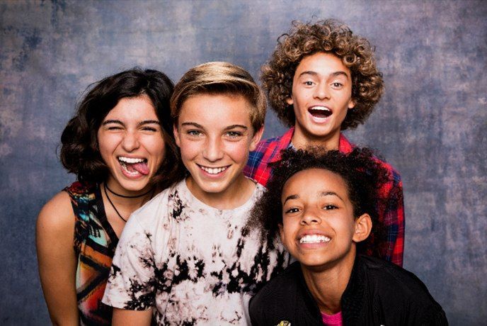 Un grupo de jóvenes posan para una foto juntos y hacen muecas divertidas.
