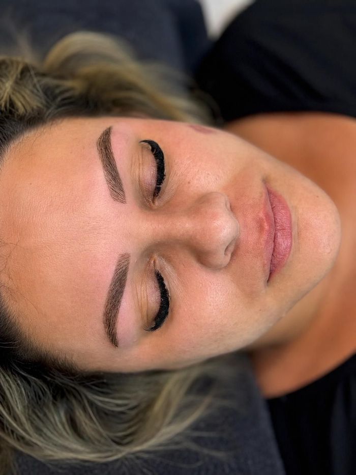 Primer plano de una persona tumbada con los ojos cerrados, mostrando las cejas bien definidas y un rostro relajado.