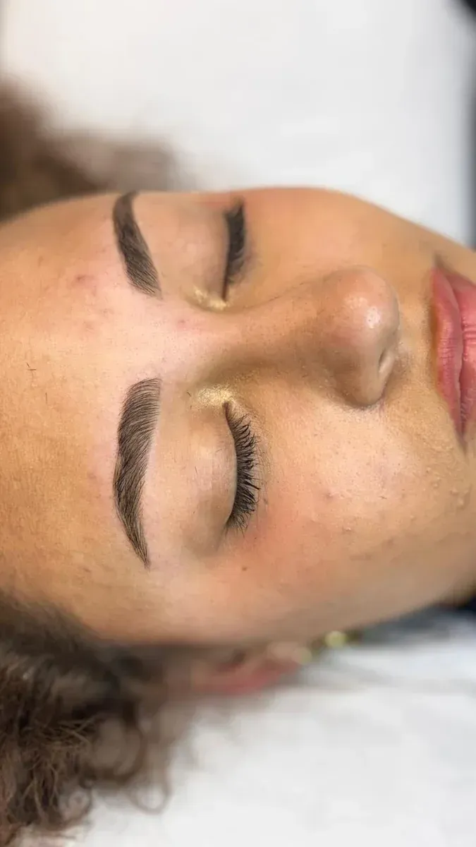 Primer plano de una persona tumbada con los ojos cerrados, mostrando las cejas bien definidas y un rostro relajado.