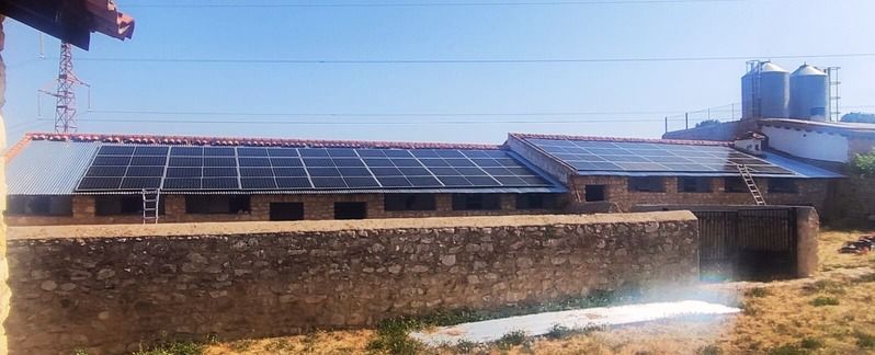 Un edificio con paneles solares en el techo en un entorno soleado.