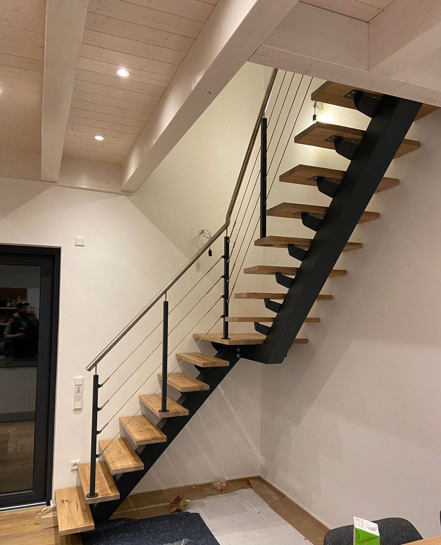 Eine Treppe mit Holzstufen und einem Metallgeländer in einem Raum.