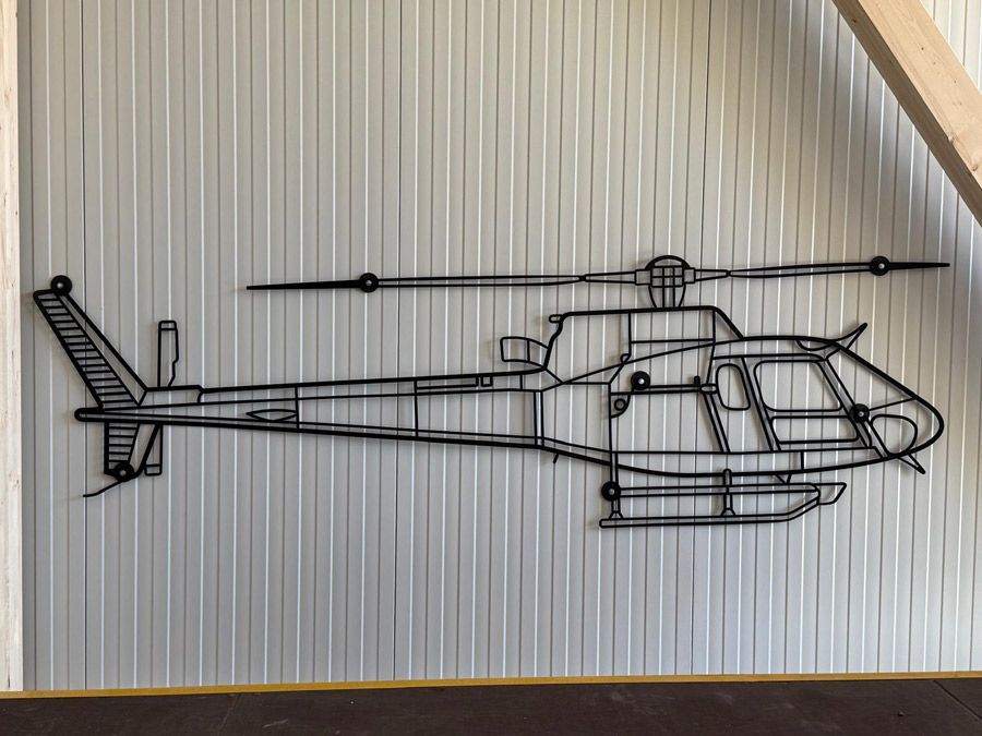 An einer Wand hängt eine Zeichnung eines Hubschraubers.