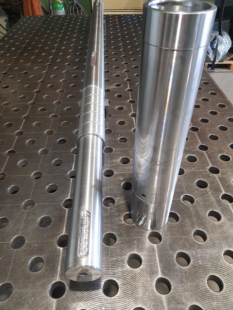 Zwei Metallrohre liegen auf einem Metalltisch.