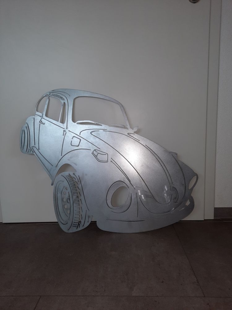 Ein Cutout eines VW Käfers hängt an einer Wand