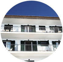 Immeuble d'appartements blanc avec balcons et balustrades se détachant sur un ciel bleu