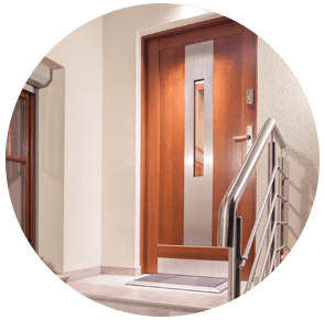 Ascenseur d'appartement en bois avec porte et rampe en acier inoxydable dans un couloir