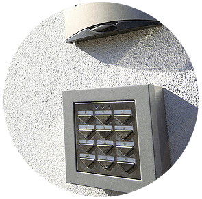 Interphone mural et clavier sur un mur extérieur en stuc blanc