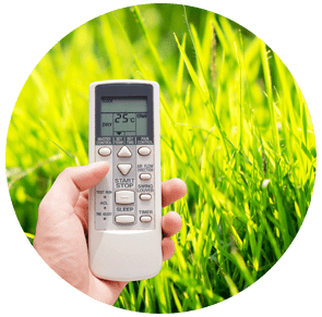 Main tenant une télécommande devant une pelouse d'un vert éclatant