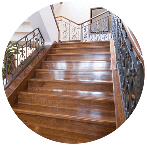 Escalier en bois avec rampes en métal ornées dans un hall d'entrée intérieur lumineux