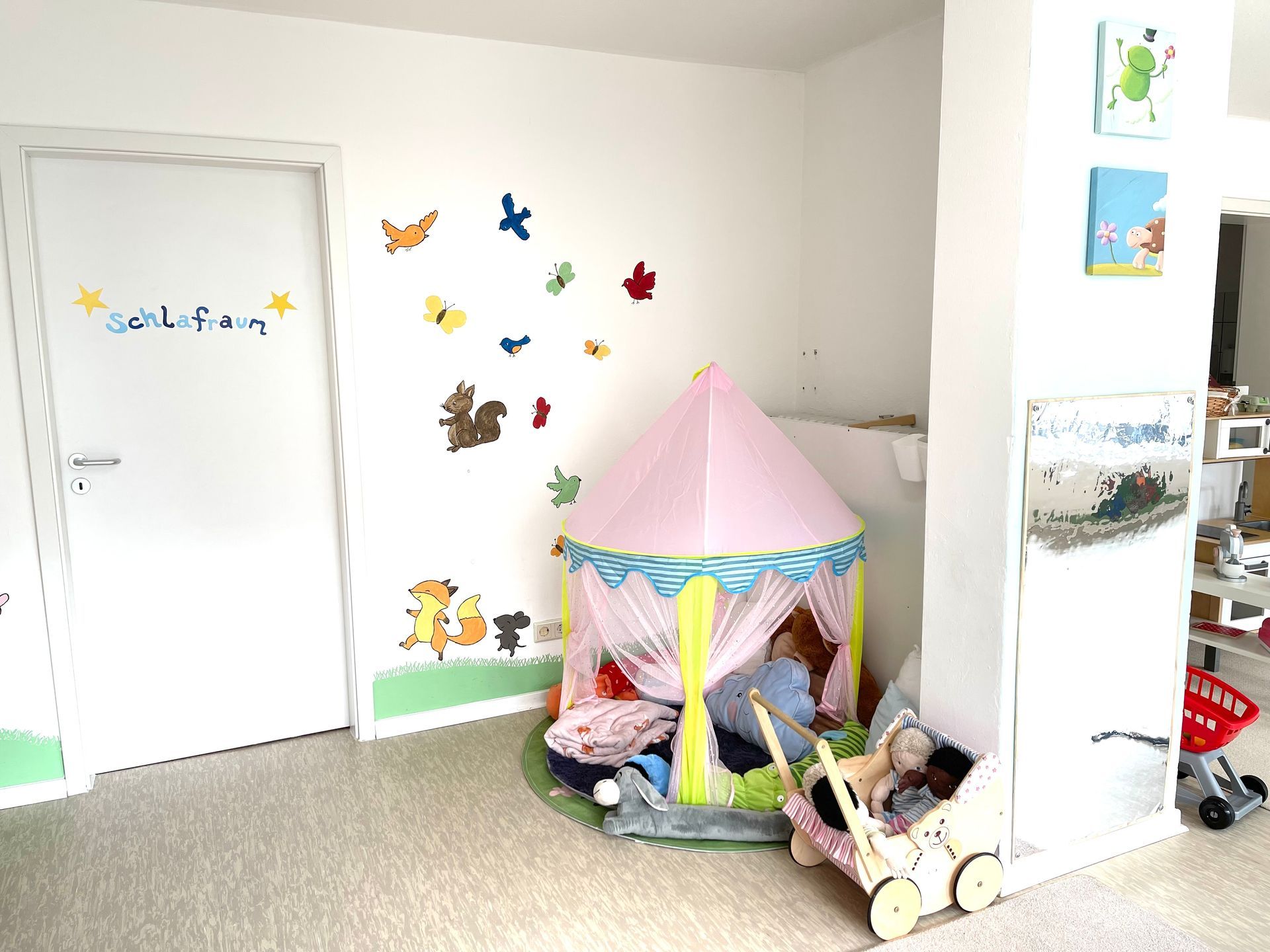 Ein Raum mit einem rosa Zelt und einem Kinderwagen darin