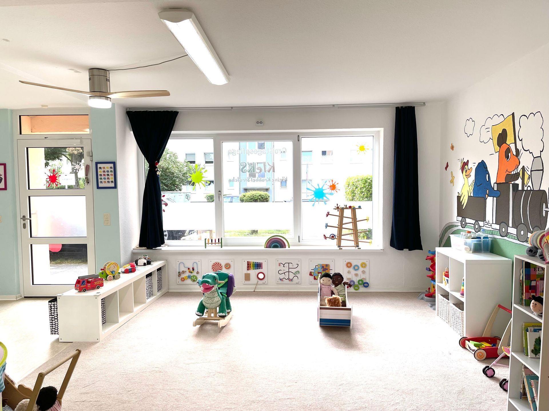 Ein großer Raum voller Spielsachen und einem Fenster.