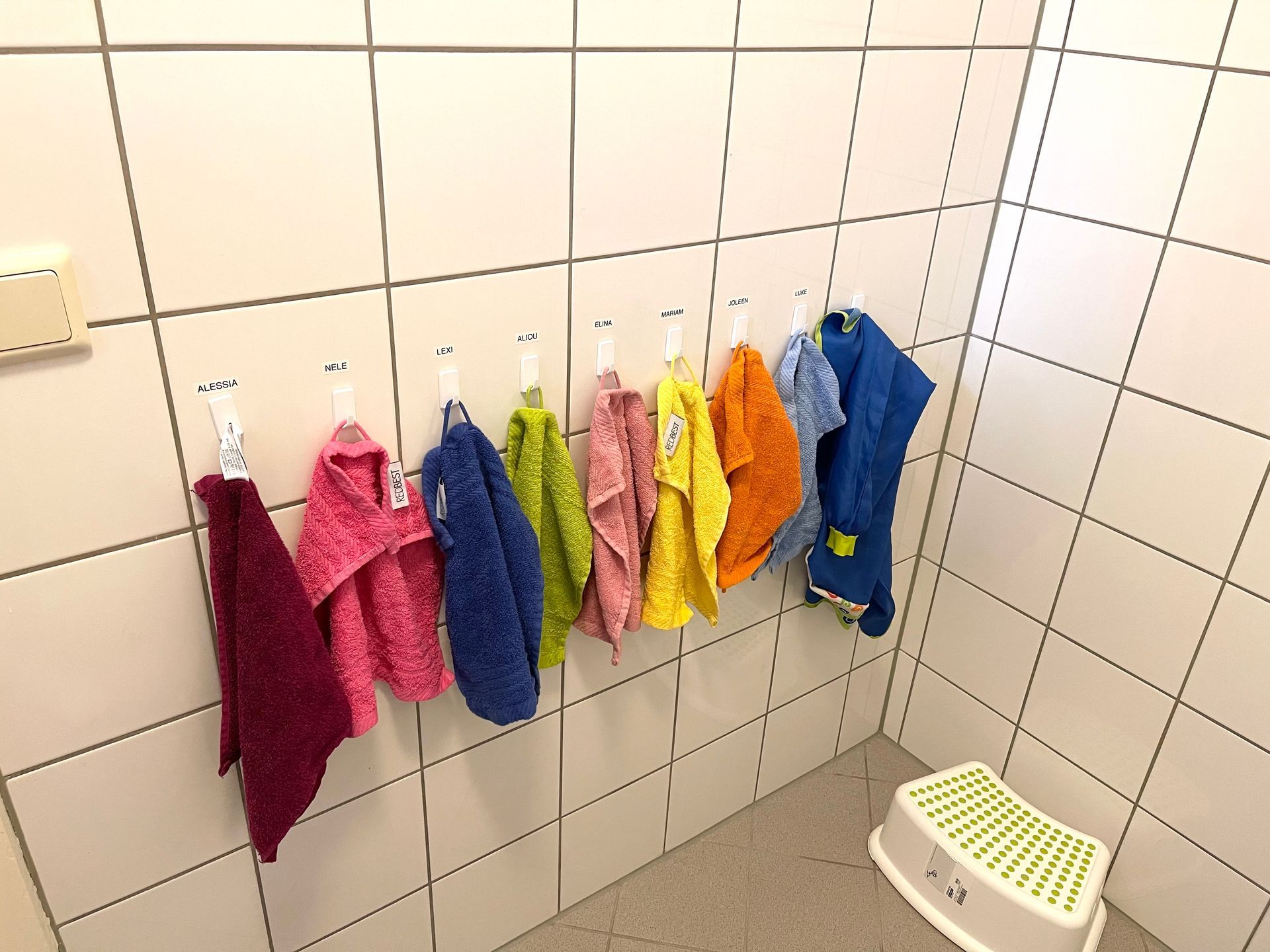 Eine Reihe Handtücher hängen an Haken in einem Badezimmer