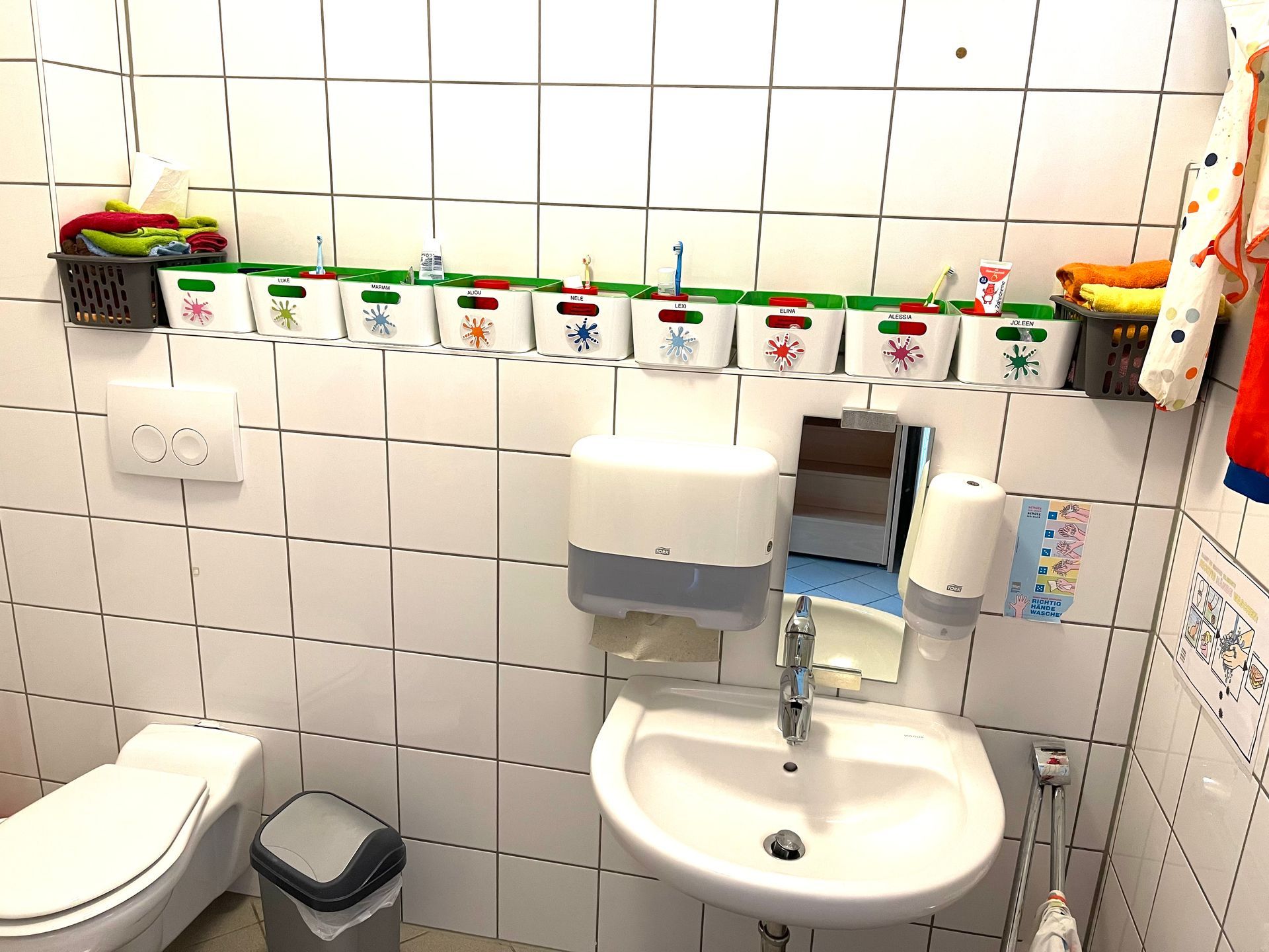 Ein Badezimmer mit Toilette, Waschbecken und Mülleimer