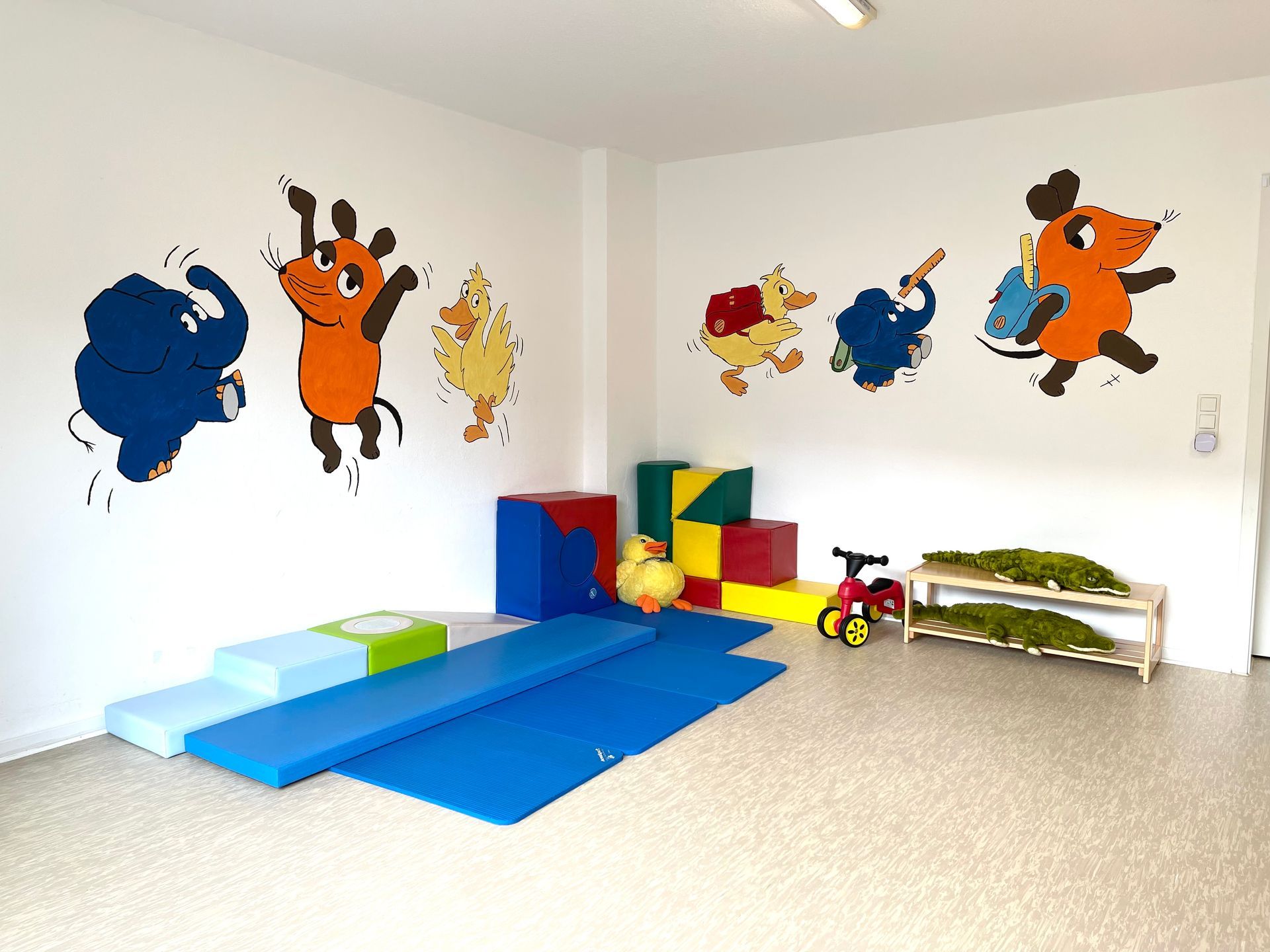 Ein Zimmer mit vielen Spielsachen und einem Tiergemälde an der Wand.