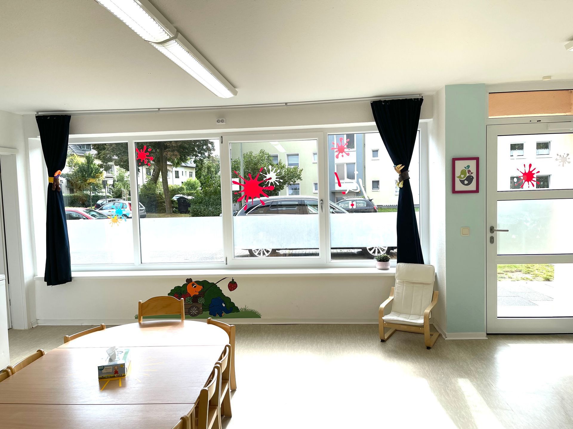 Ein Raum mit Tisch und Stühlen und einem großen Fenster