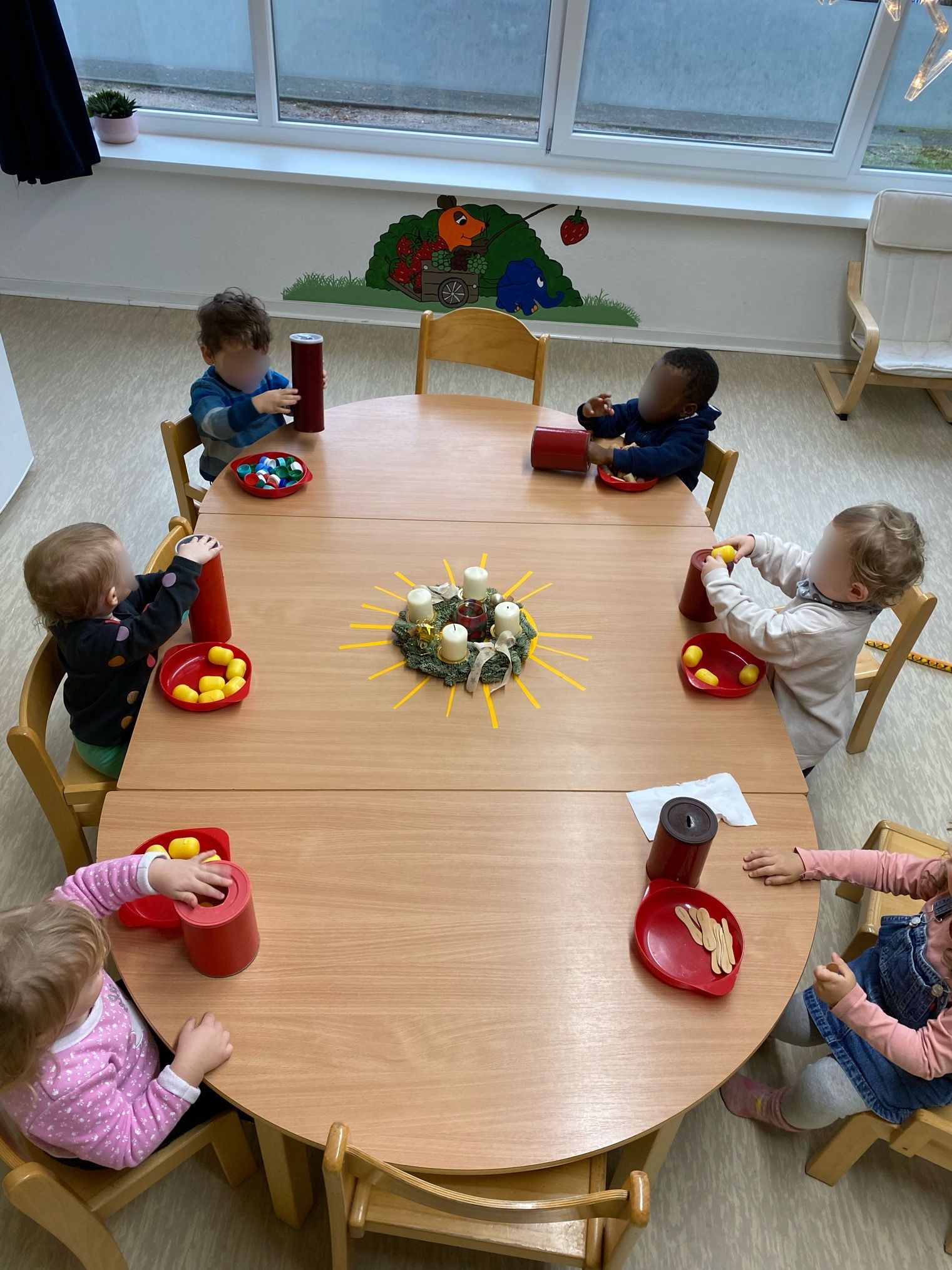 Eine Gruppe Kinder sitzt um einen Tisch herum.