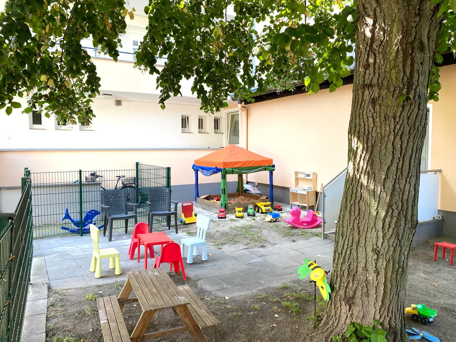 Ein Garten mit Tischen und Stühlen.