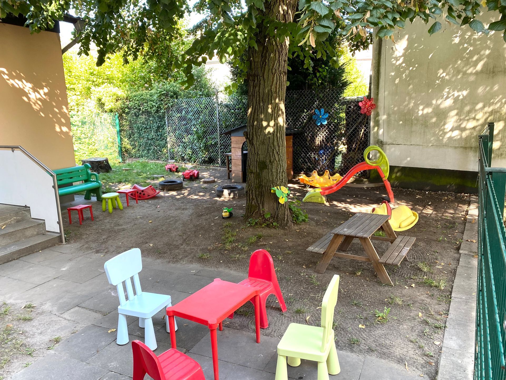 Kinderstühlen und -tischen in einem Hinterhof.