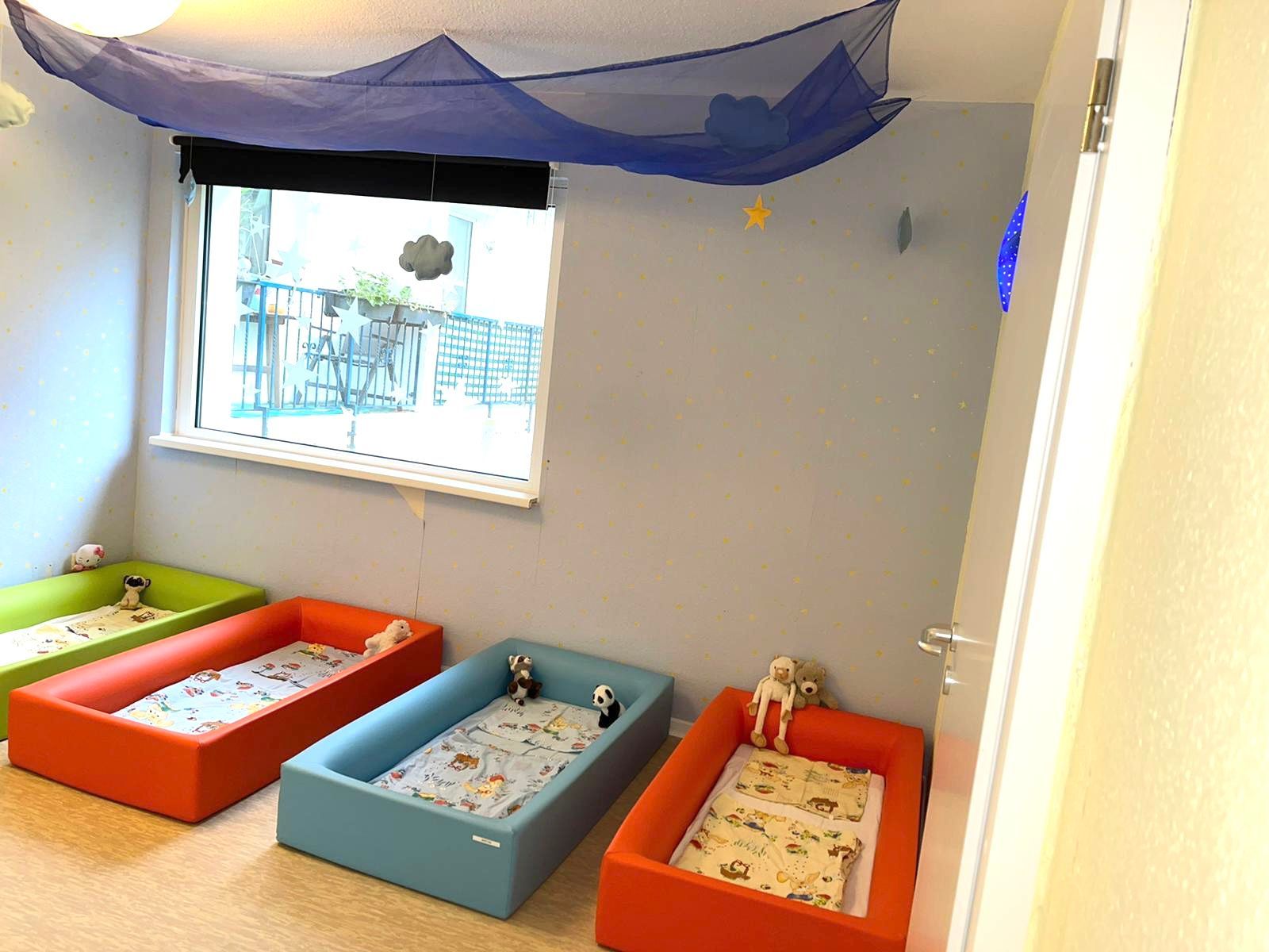 Ein Zimmer mit vielen Betten und einem Fenster.