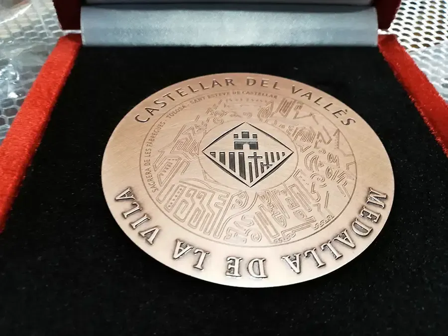 En medal that says medalla de la villa donde it