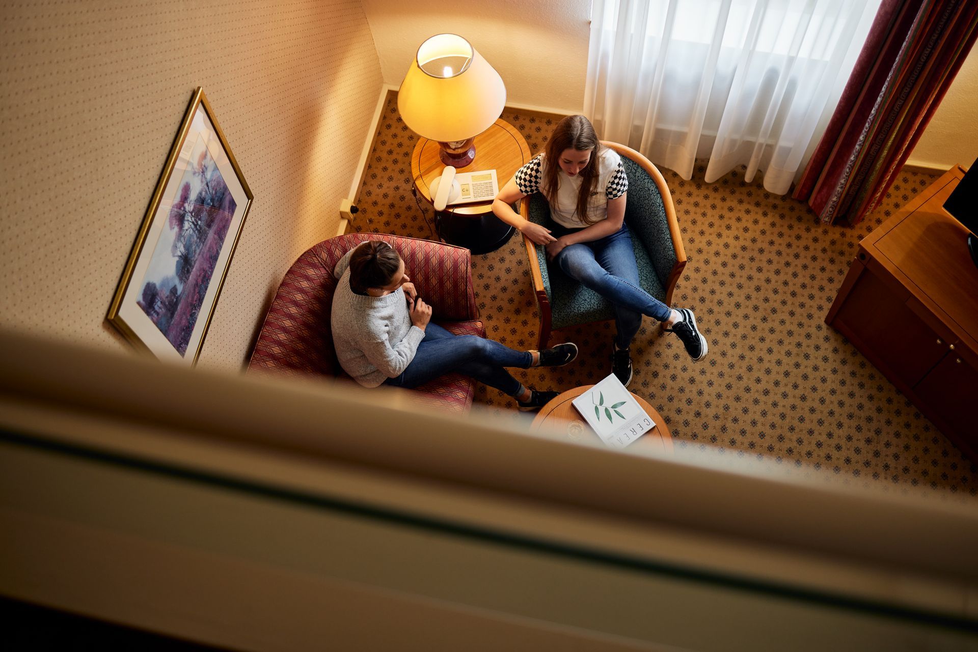 Eine Person hält ein Holztablett mit verschiedenen Backwaren; Croissants, Brot und ein Keks sind zu sehen.