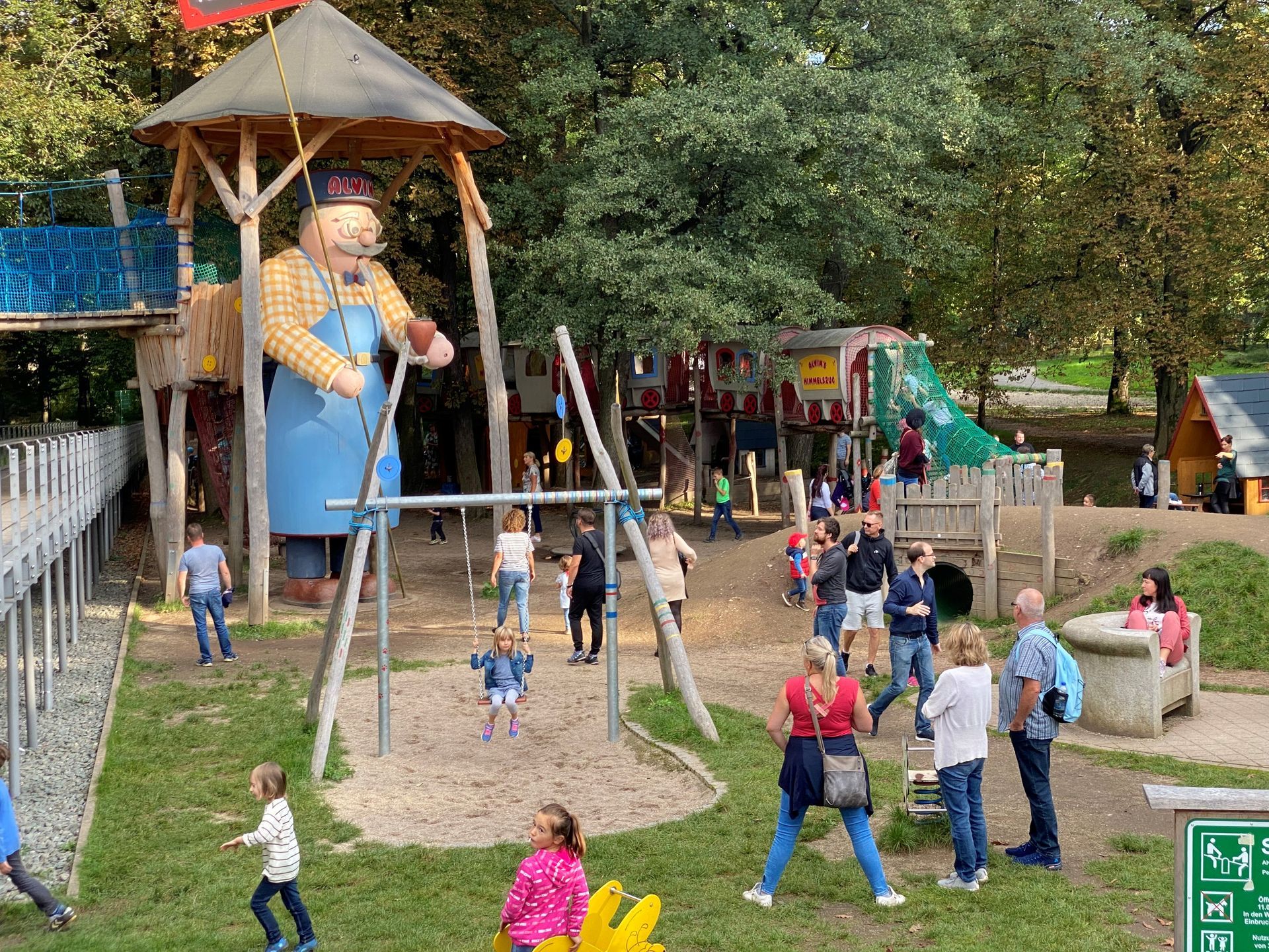 Menschen auf einem Spielplatz mit Eisenbahn und dem größten Räuchermann der Welt.
