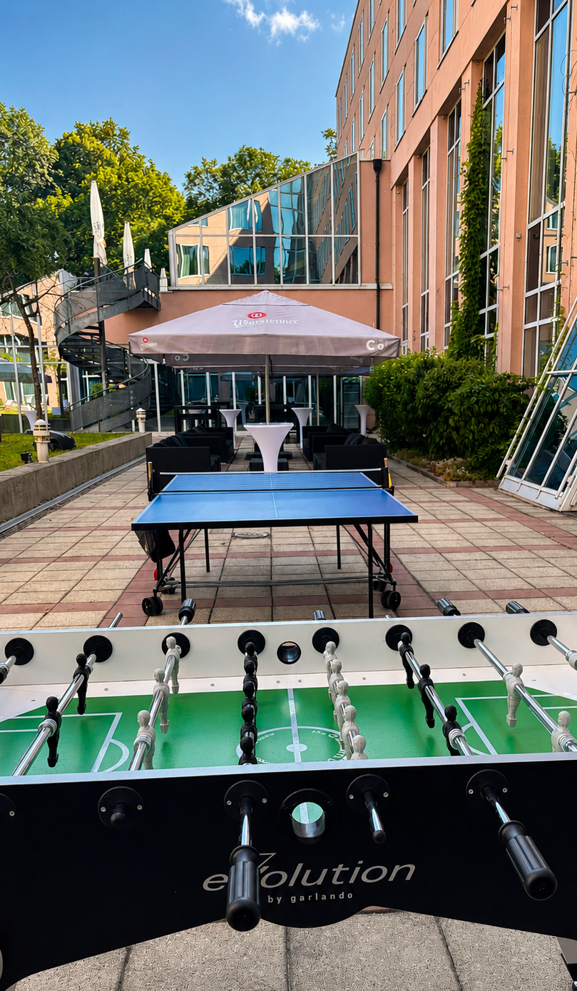 Die c/o56 Chemnitz Hotelterrasse mit Tischtennisplatten und Tischfußballtischen.