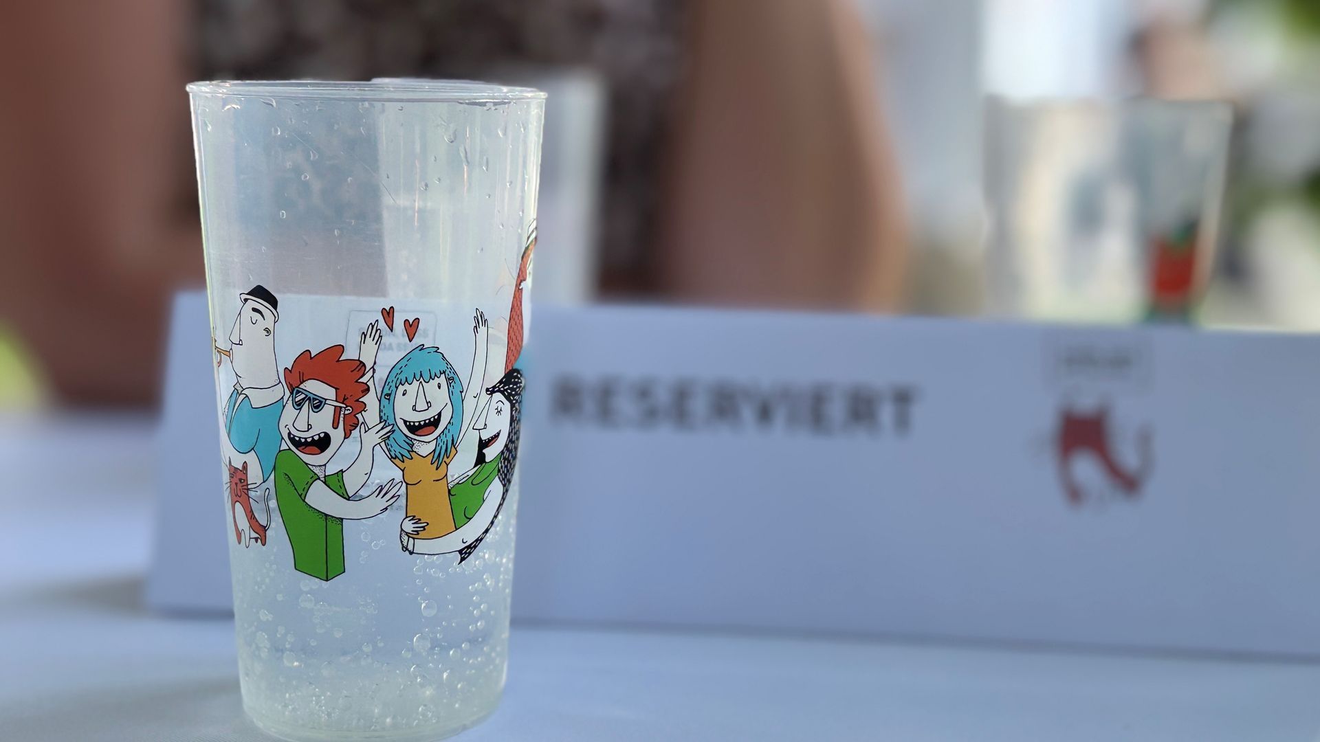 Ein Parksommer-Becher auf einem Tisch, im Hintergrund ist ein verschwommenes Reserviert Schild