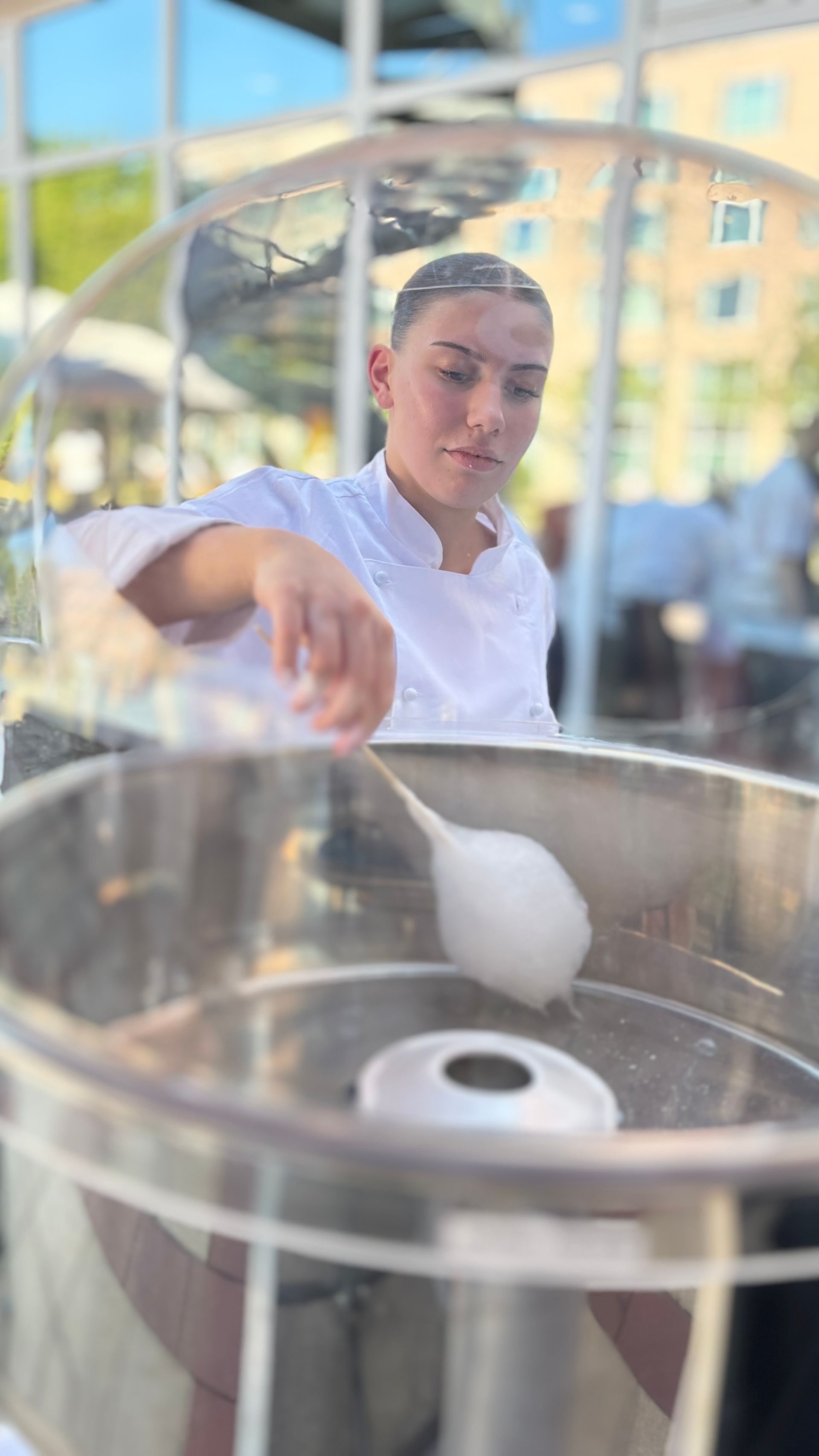 Eine Person stellt zum Schulanfang im Hotelgarten des c/o56 Chemnitz Zuckerwatte her.