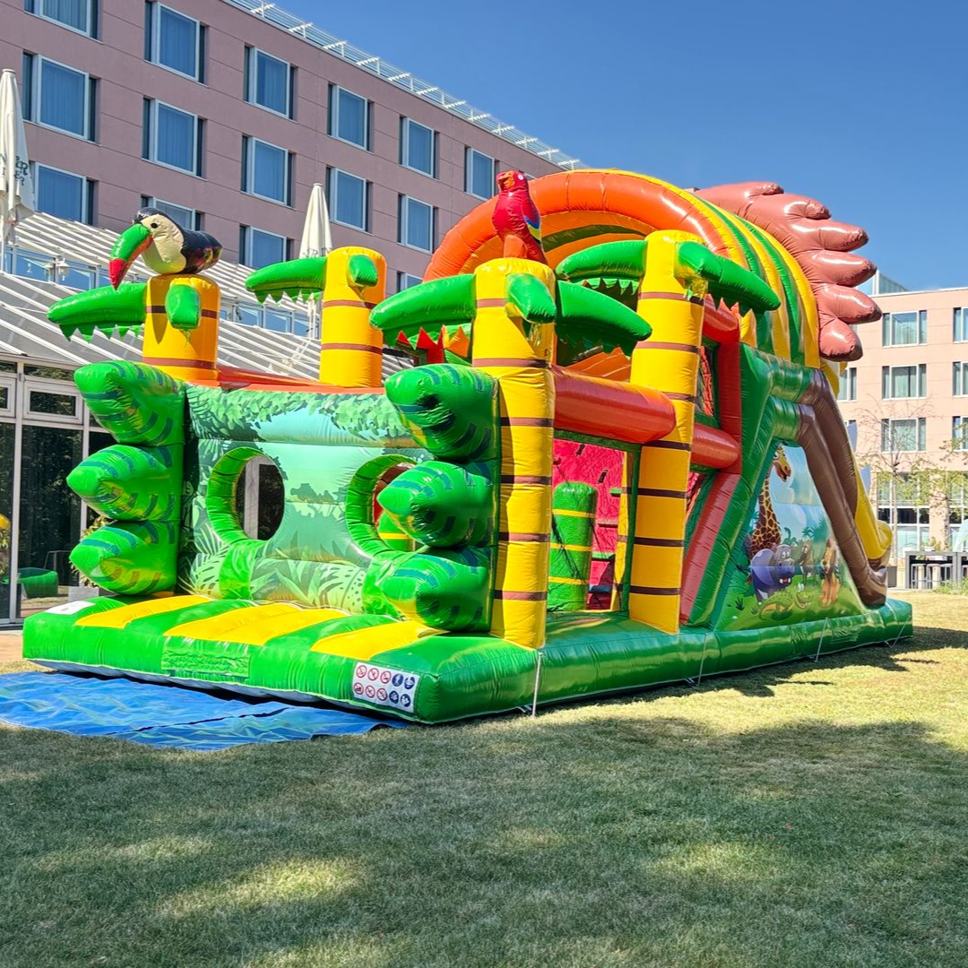 Eine bunte Hüpfburg für den Schulanfang auf einer Rasenfläche vor dem Hotel c/o56 Chemnitz.