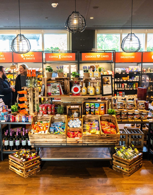 Ein Foto vom hoteleigenen Shop namens c/onsum56. Lebensmittelregale mit voller Snacks und Feinkostartikel.