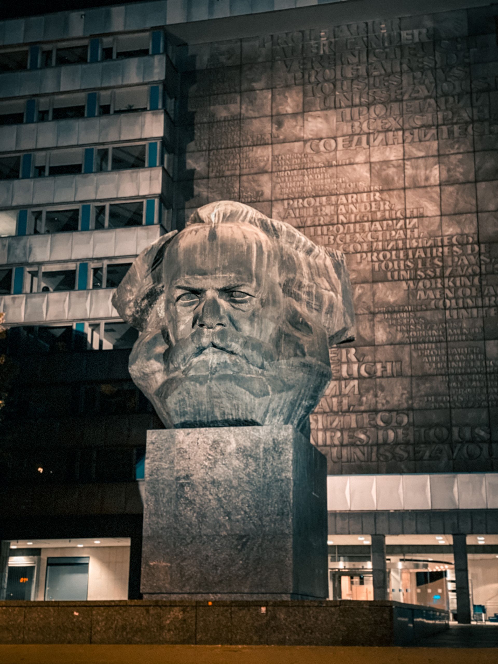 Ein reich verziertes Wohnhaus mit Balkonen und farbenfroher Kachelfassade, eingerahmt von Bäumen vor blauem Himmel.