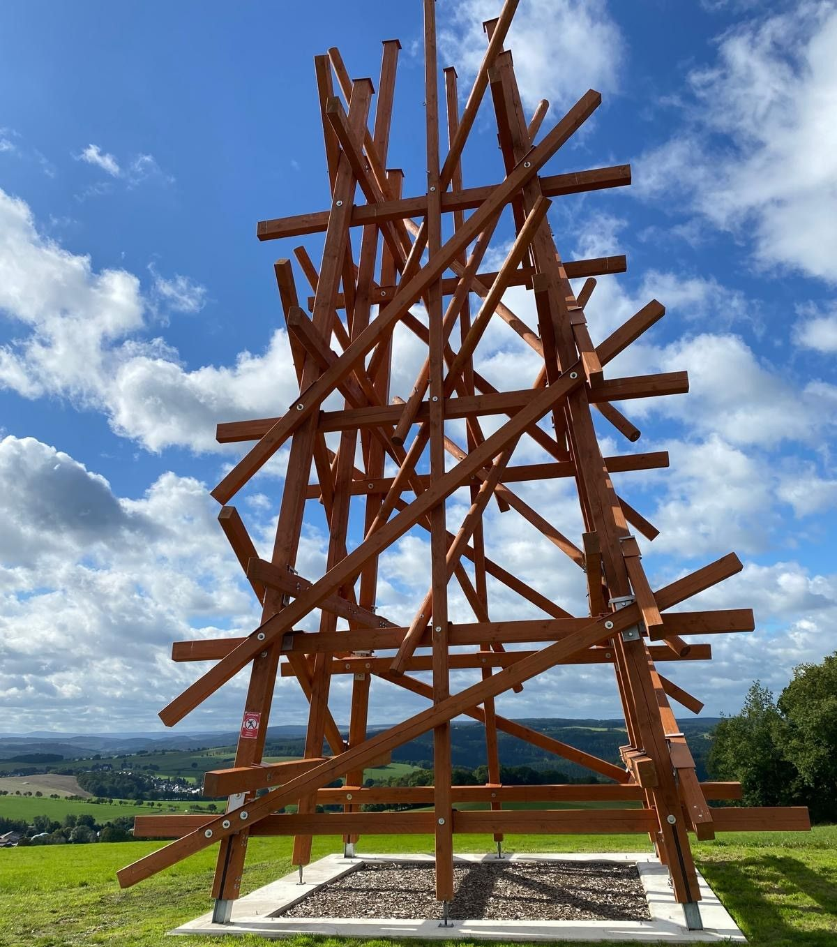 Menschen versammeln sich an einem Teich vor einem Gebäude, über dem ein Festivallogo angebracht ist.