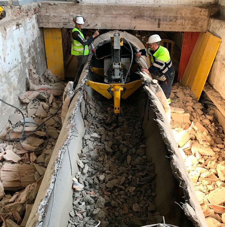 Dos hombres están trabajando en un barco en un túnel de hormigón.