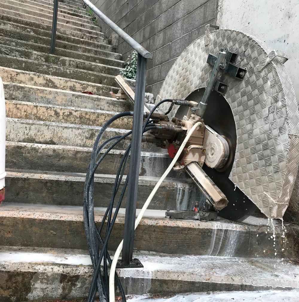 Una máquina está cortando hormigón en un tramo de escaleras.