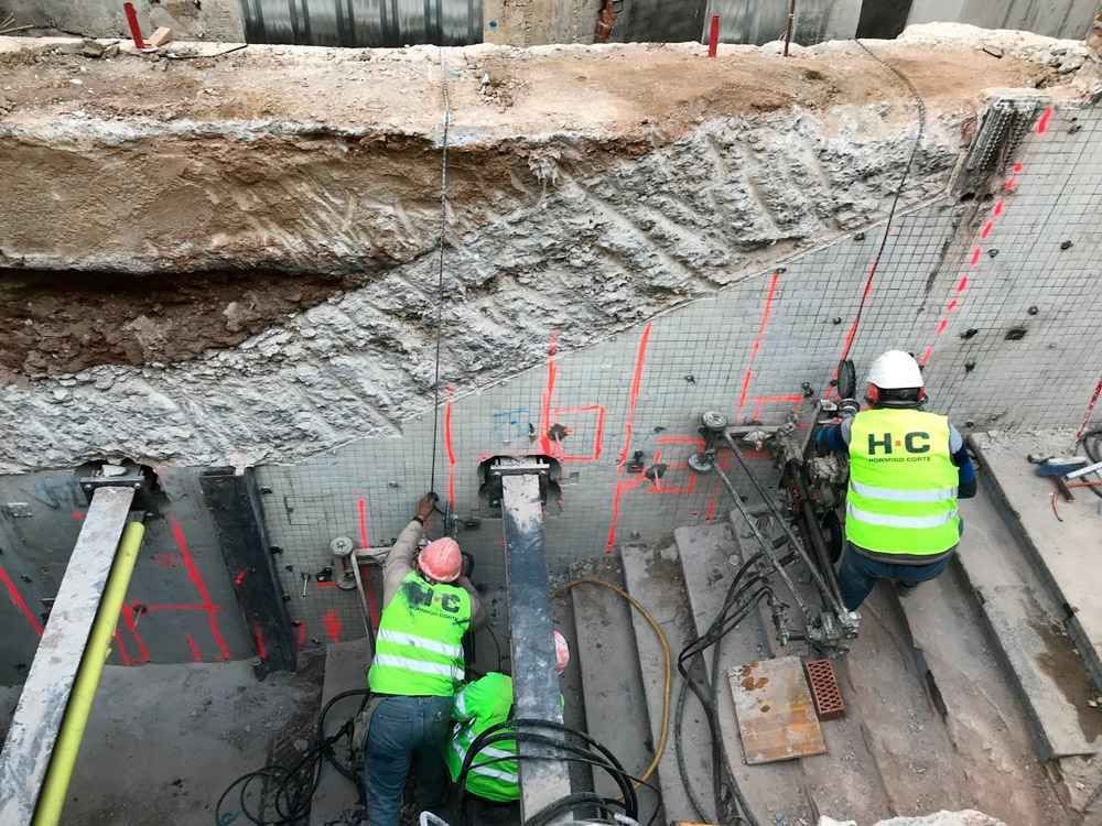 Un grupo de trabajadores de la construcción está trabajando en un muro de hormigón.