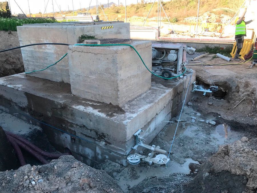 Un gran bloque de hormigón está siendo cortado por la mitad por una máquina.