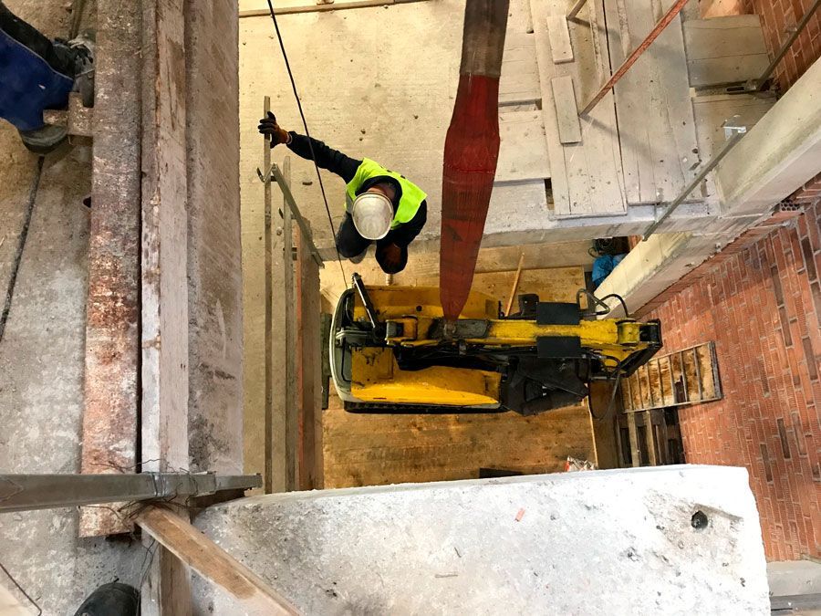 Un hombre está trabajando en una grúa en un edificio.