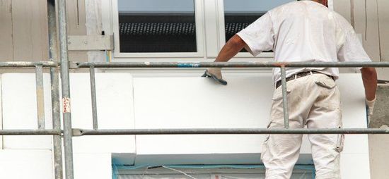 Maler arbeitet an einer Fassade