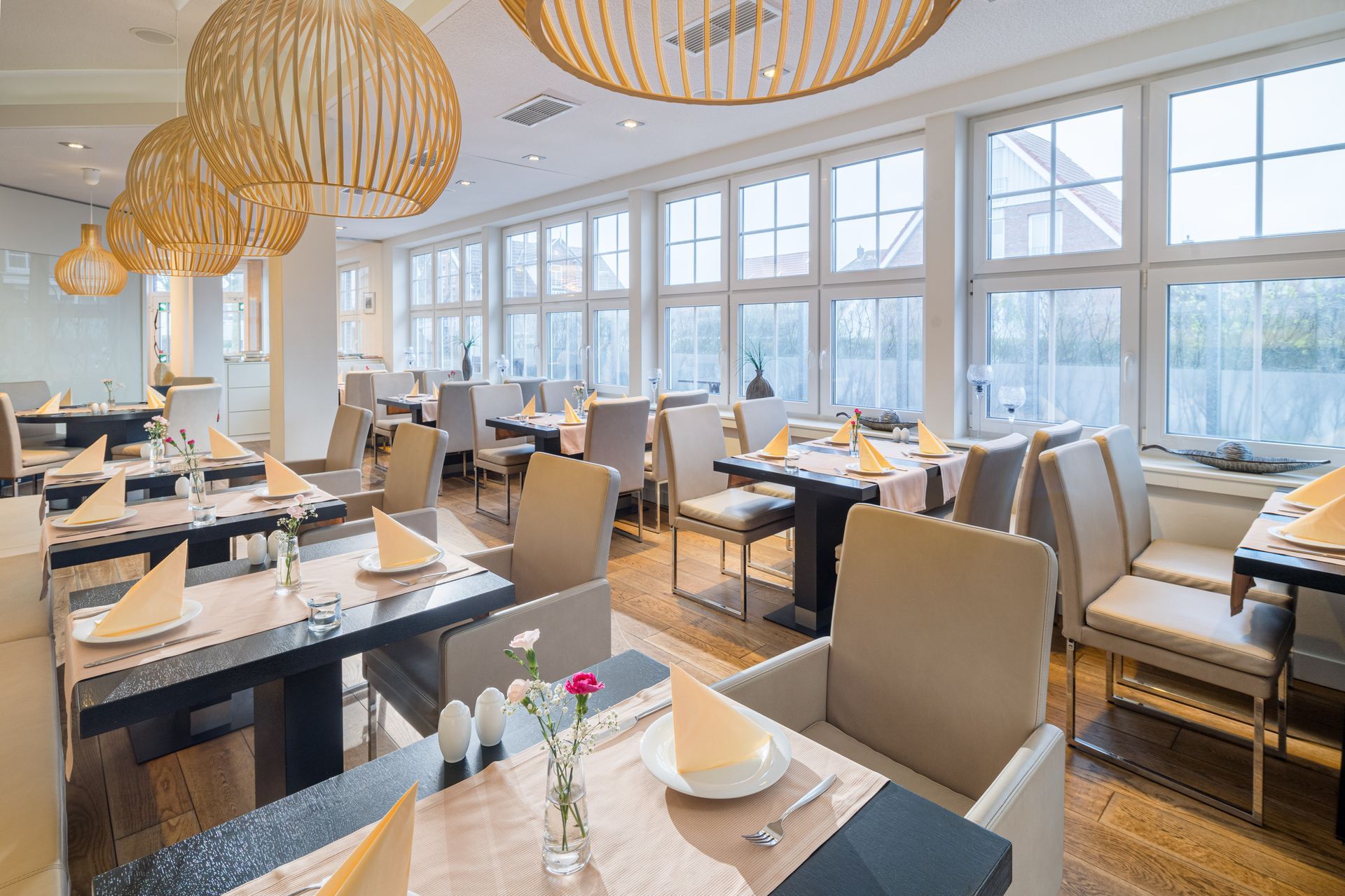 Speisesaal eines Restaurants mit für Gäste gedeckten Tischen.