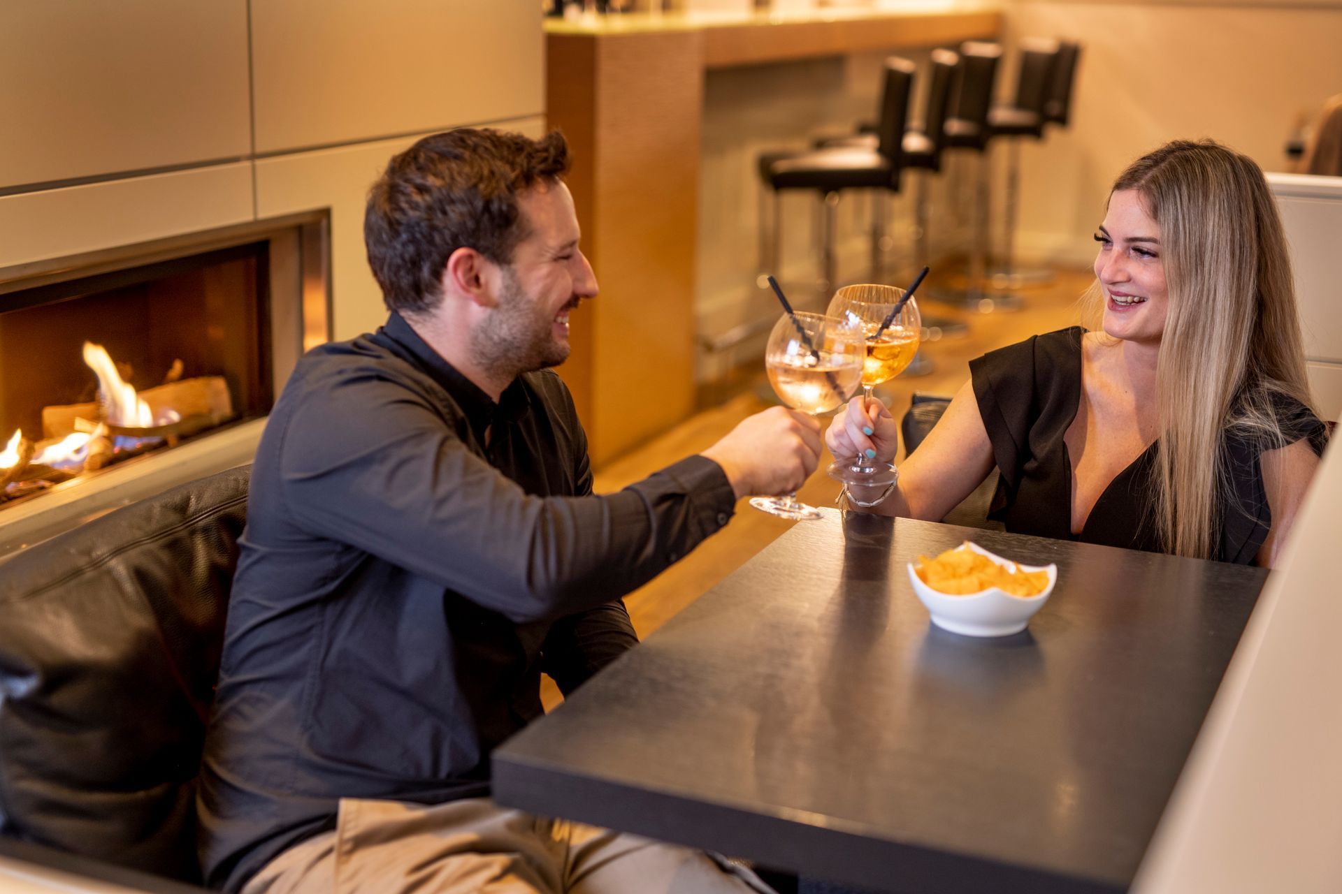 Blauer Margarita-Cocktail in einem Stielglas, garniert mit Limette und Minze, auf einer Holzoberfläche.