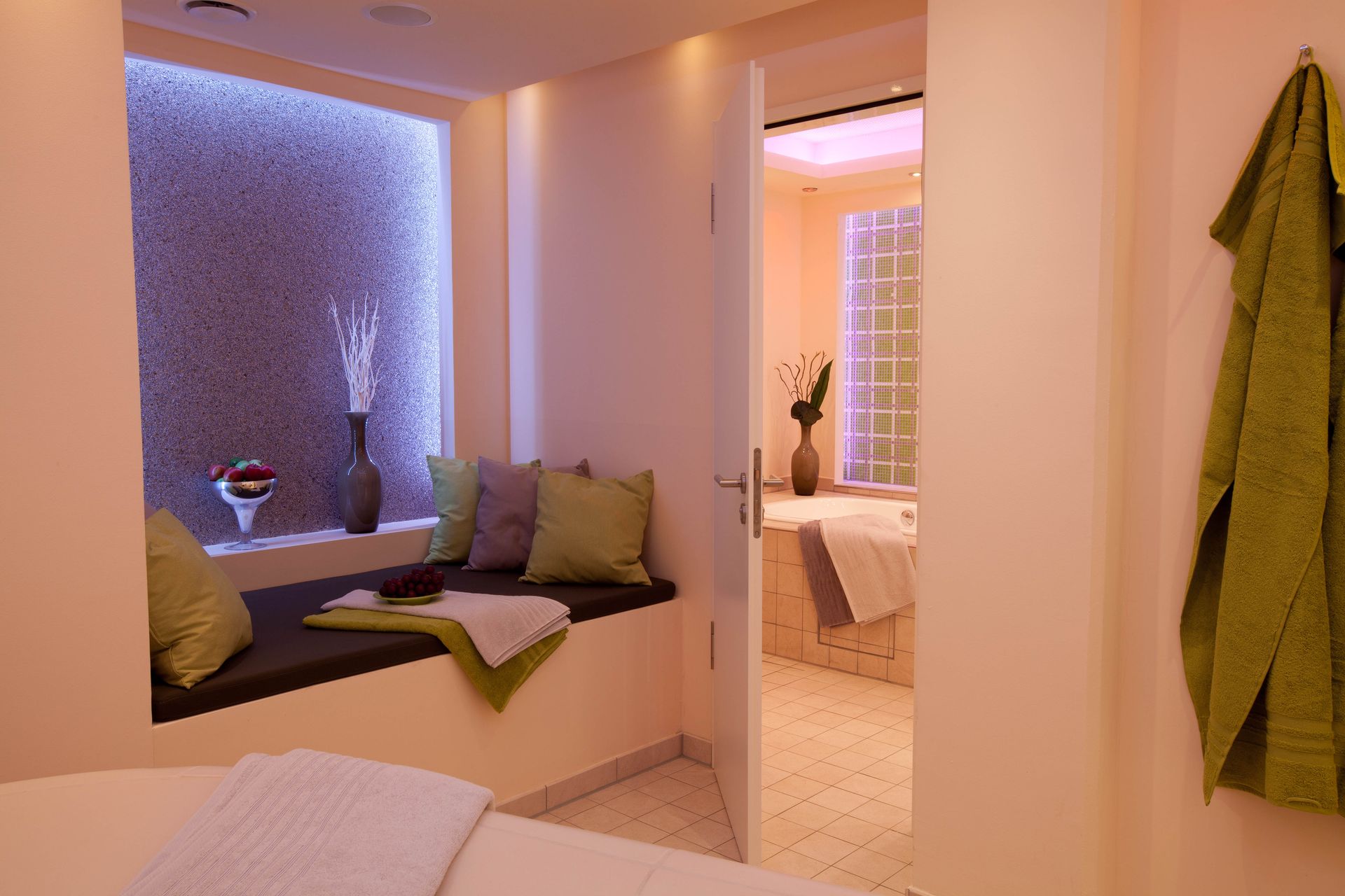 Spa-Innenraum mit Fensterplatz, Badezimmer und grünen Handtüchern.