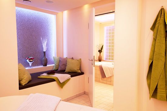 Loungesessel. Erdfarbene Umgebung mit Pflanzen im Hintergrund.