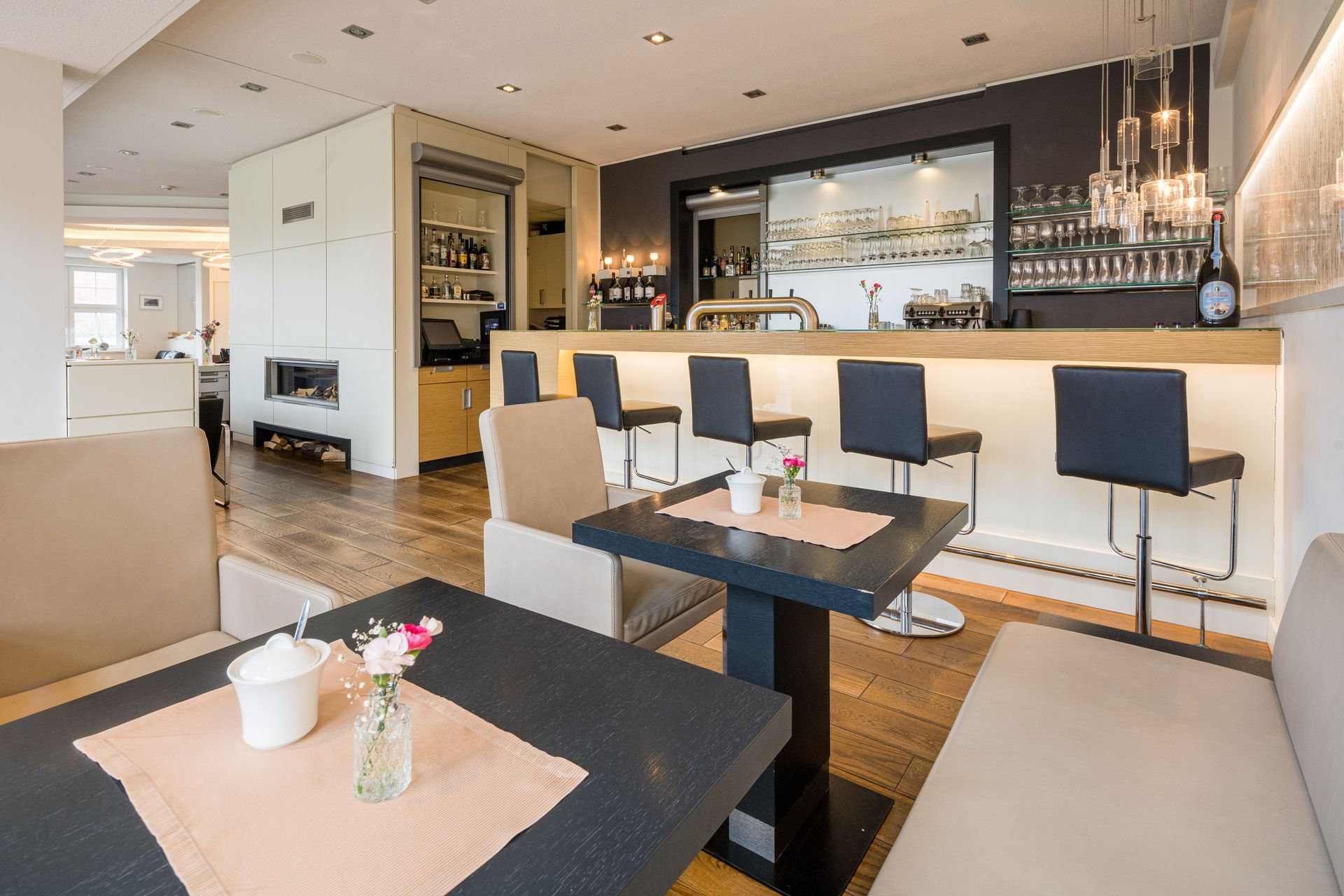 Bar-Interieur mit Barhockern, Tischen und neutralem Farbschema.