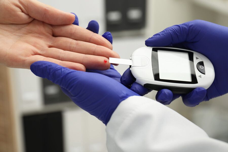 Un profesional sanitario con guantes comprueba el nivel de azúcar en sangre 
