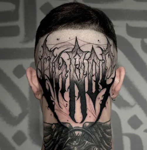 Tatuaje negro que cubre la parte posterior de la cabeza de una persona con letras estilizadas y detalles intrincados.